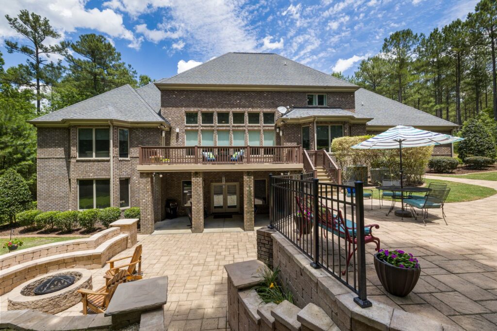Custom-built brick residence with a large terrace, fire pit, and landscaped garden
