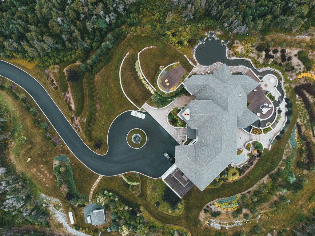 Aerial view of a custom-built luxury home with landscaped grounds and winding driveway in Westchester NY