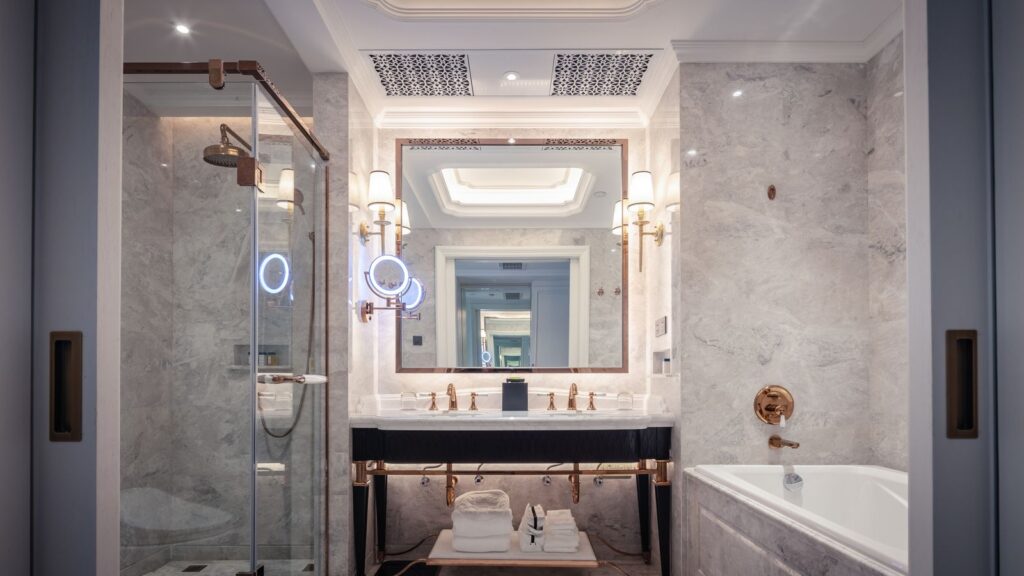 Elegant luxury bathroom remodel with marble vanity, bathtub, and ambient lighting