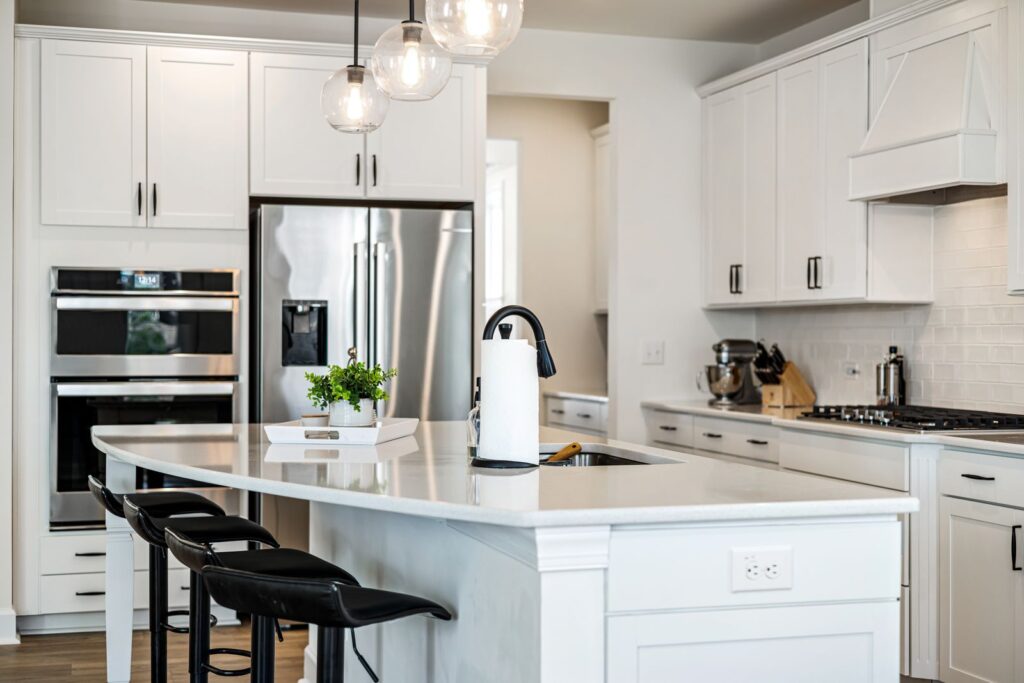 White shaker cabinetry kitchen remodel with quartz island and glass globe pendant lights
