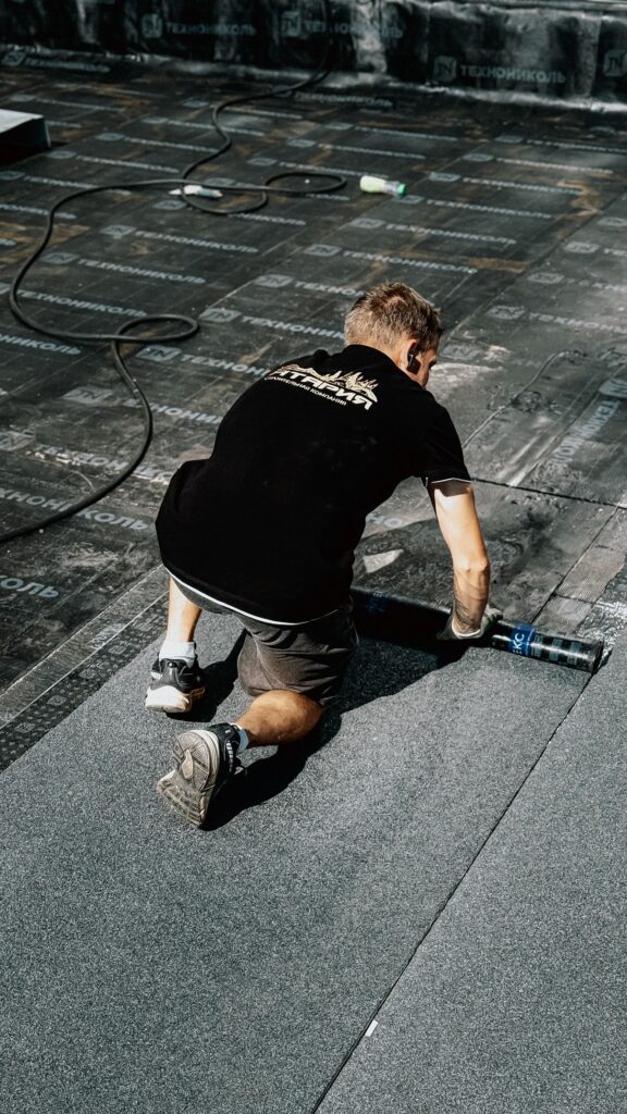 Construction worker installing asphalt shingle roofing material on a Westchester NY home