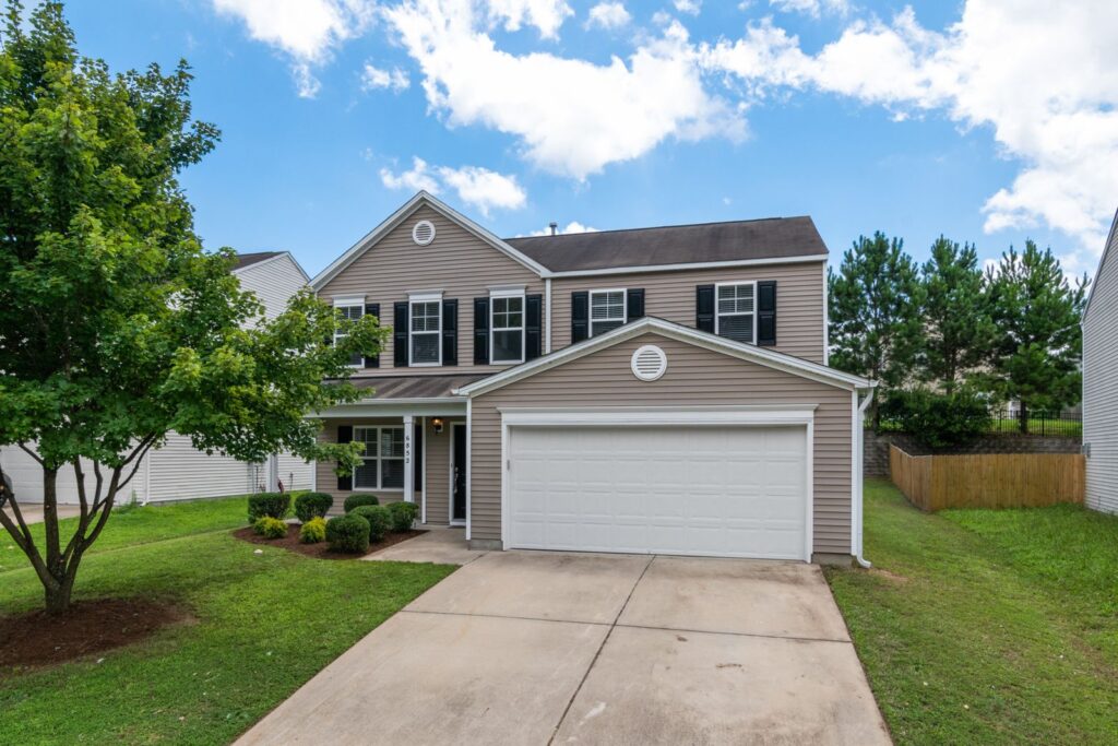 Two-story suburban Westchester NY home with new siding, green lawn, and two-car garage